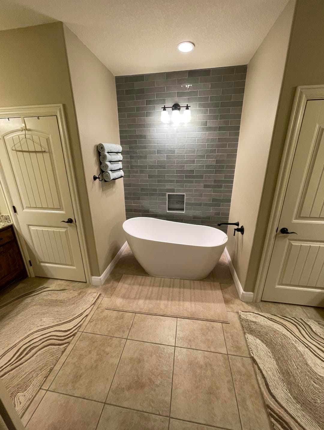 Modern bathroom remodel with freestanding tub and tile accent wall