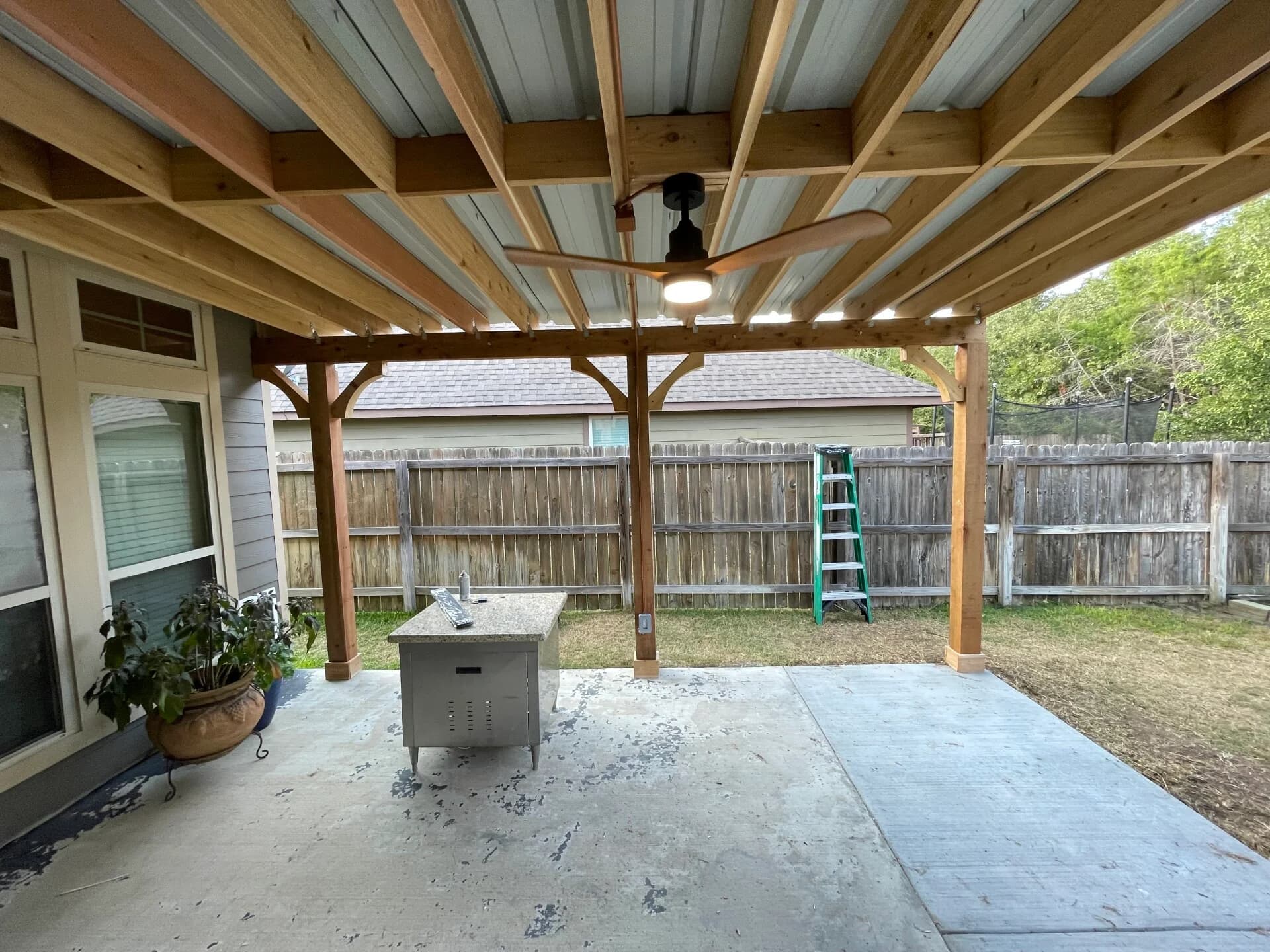 Covered patio extension with cedar beams and ceiling fan